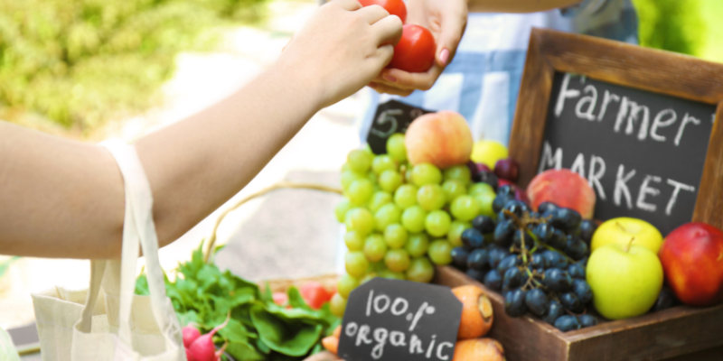 shopper buying produce at the farmers market