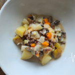 Creamy Potato Barley Soup in a white bowl on a table